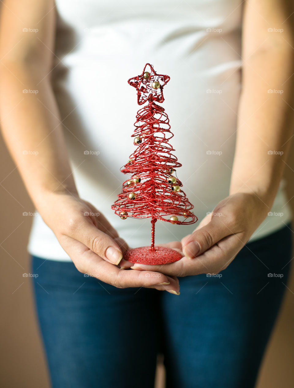 Midsection view of pregnant woman holding Christmas tree