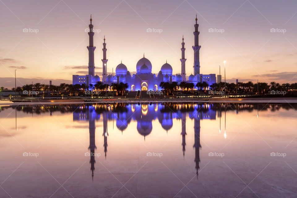 Sheikh Zayed Grand mosque in Abu Dhabi at sunset with reflection in the lake
