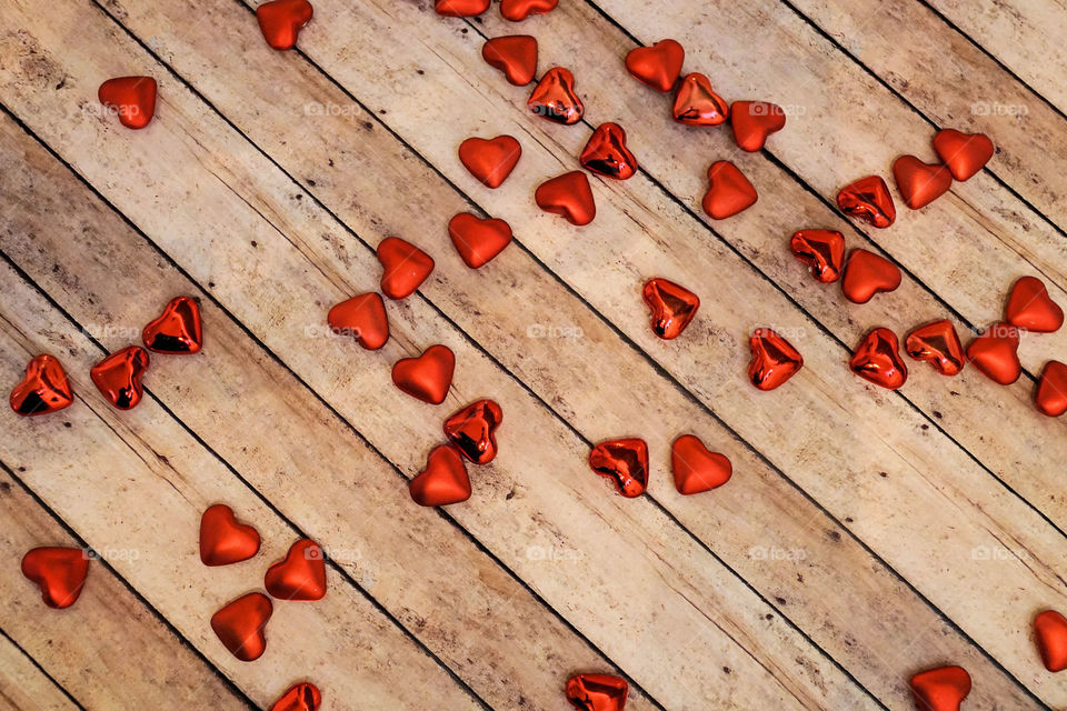 Red hearts on wooden plank