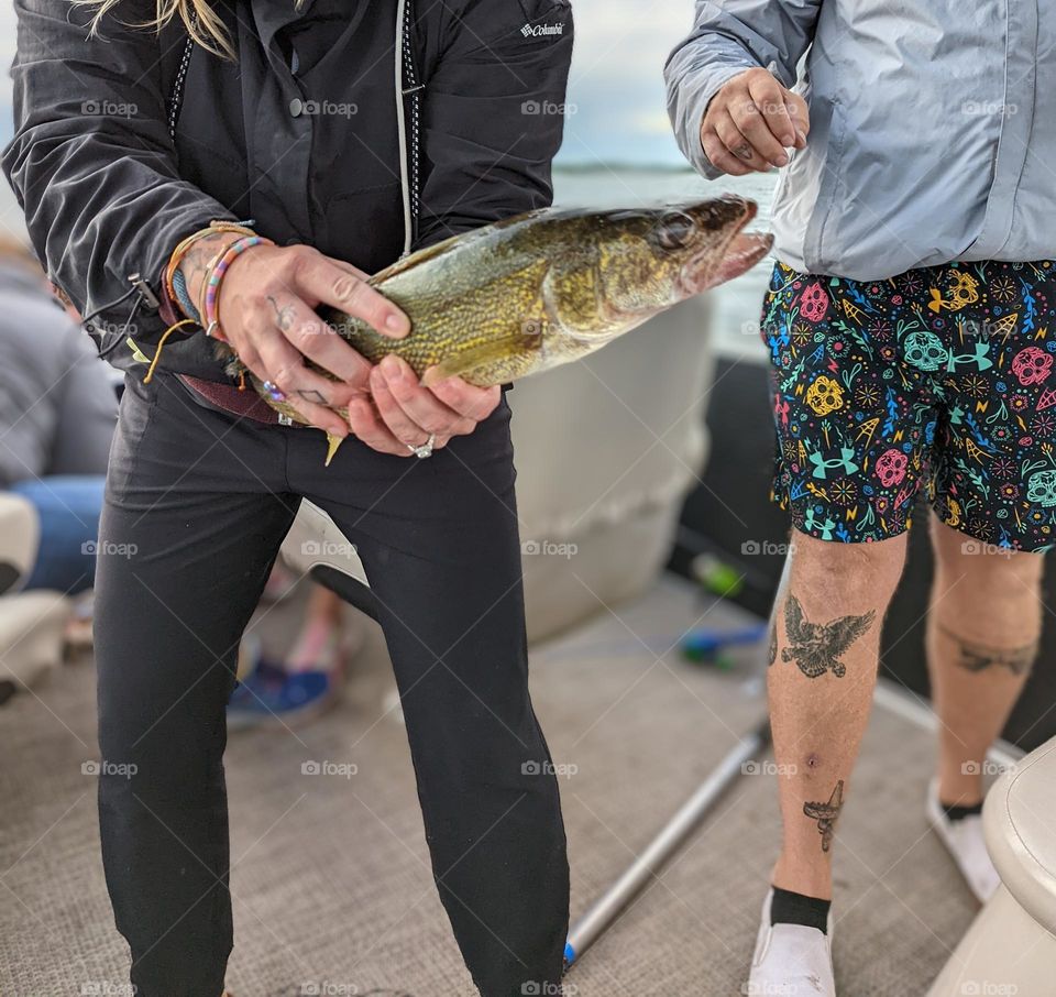 woman holding large walleye fish, women fishing, woman holding fish, girl fishing, slimy walleye fish, fishing on a pontoon