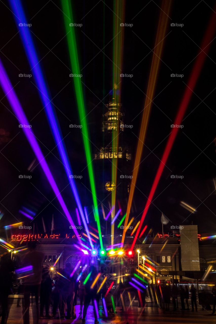 San Francisco Pride 2023 laser light display of the pride flag colors illuminating the sky in front of the Ferry Building on the Embarcadero
