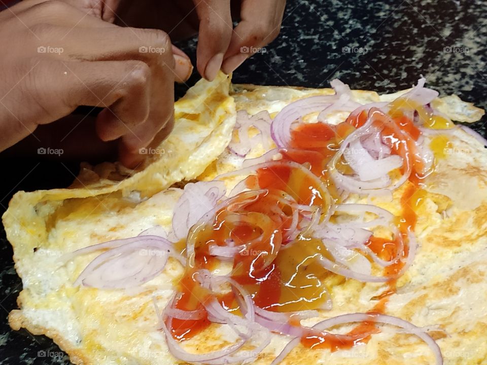 Indian food is known for spicy and diversity.North Indian Street food - Kolkata cutti roll is Indian bread packed with spicy chicken curry, sauce and onions wrapped with omlet