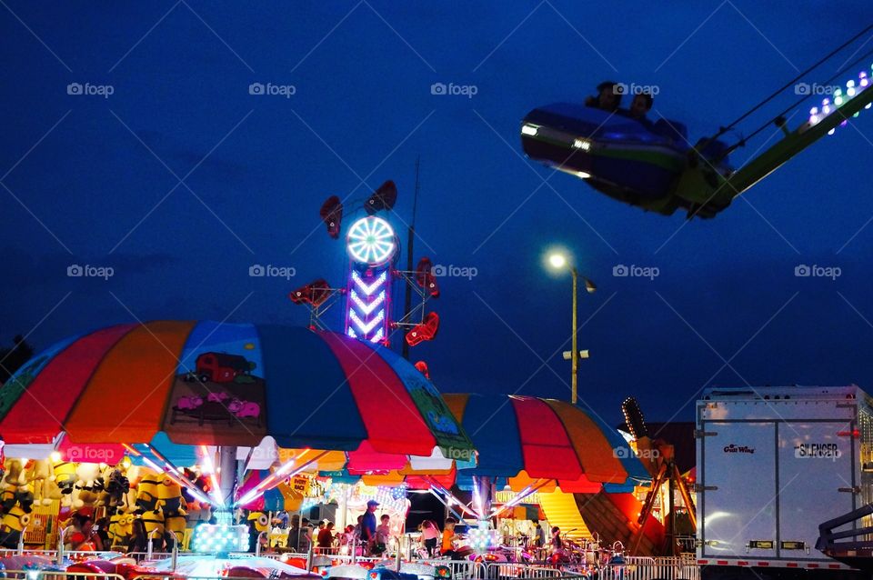 Carnival at night. Flying car over carnival