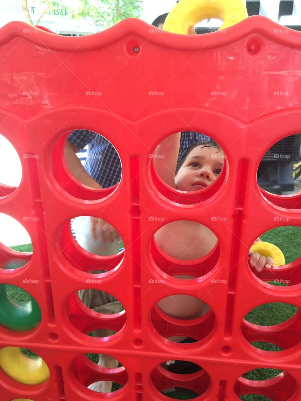 Child playing giant Connect Four game.