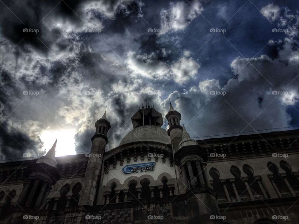 Hdr of sun piercing clouds over building 