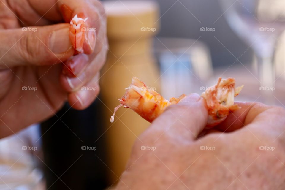 Eating prawns seafood, mature male hands holding cooked fresh prawns closeup concept dining, cooking, cuisine, seafood  