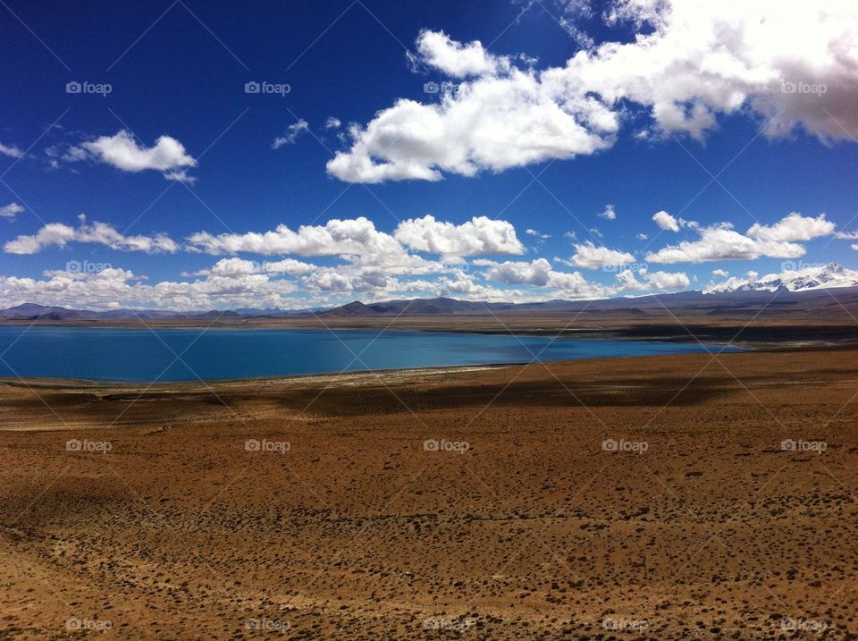 beautiful sacred lake in Tibet landscape with cloudy sky and mountain peaks