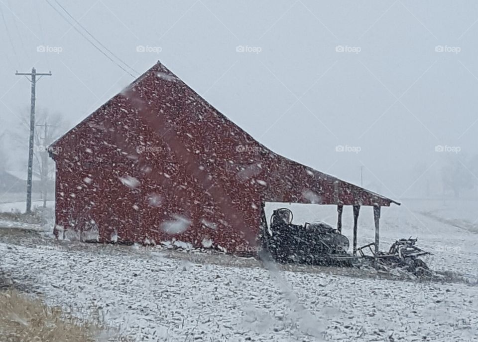 snowy barn with farm equiptment