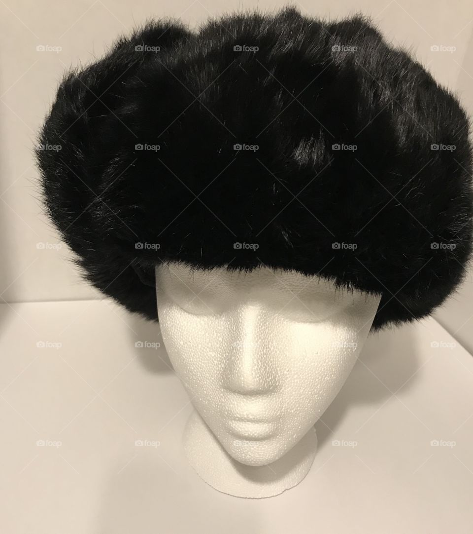 Fluffy black rabbit fur trapper style hat on styrofoam head in white box