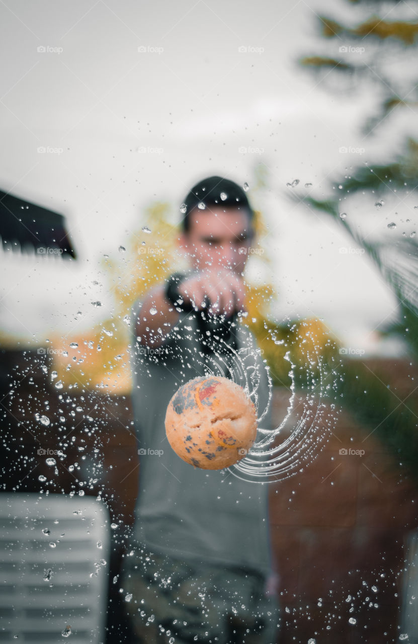 Photographer shooting a ball, sprinkling water in a spiral shape
