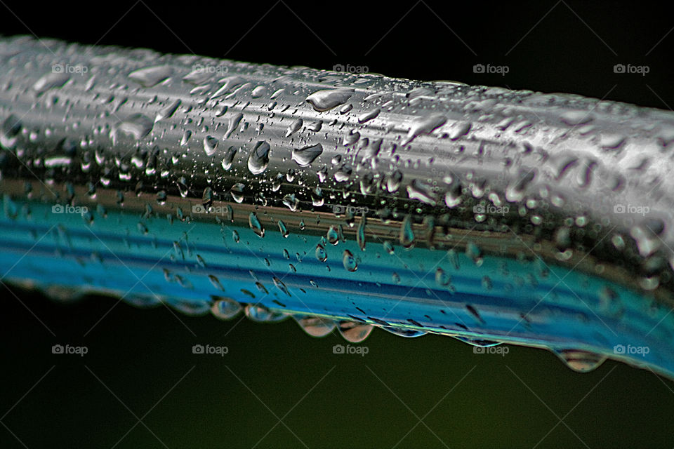 Raindrops on pool rail during a storm