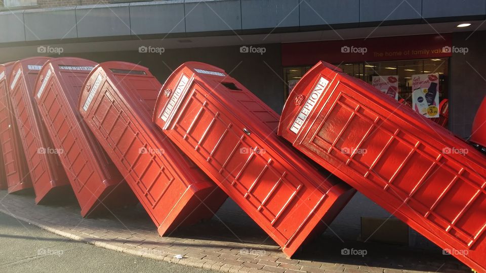 Old school red telephone booths fallen over like fallen soldiers