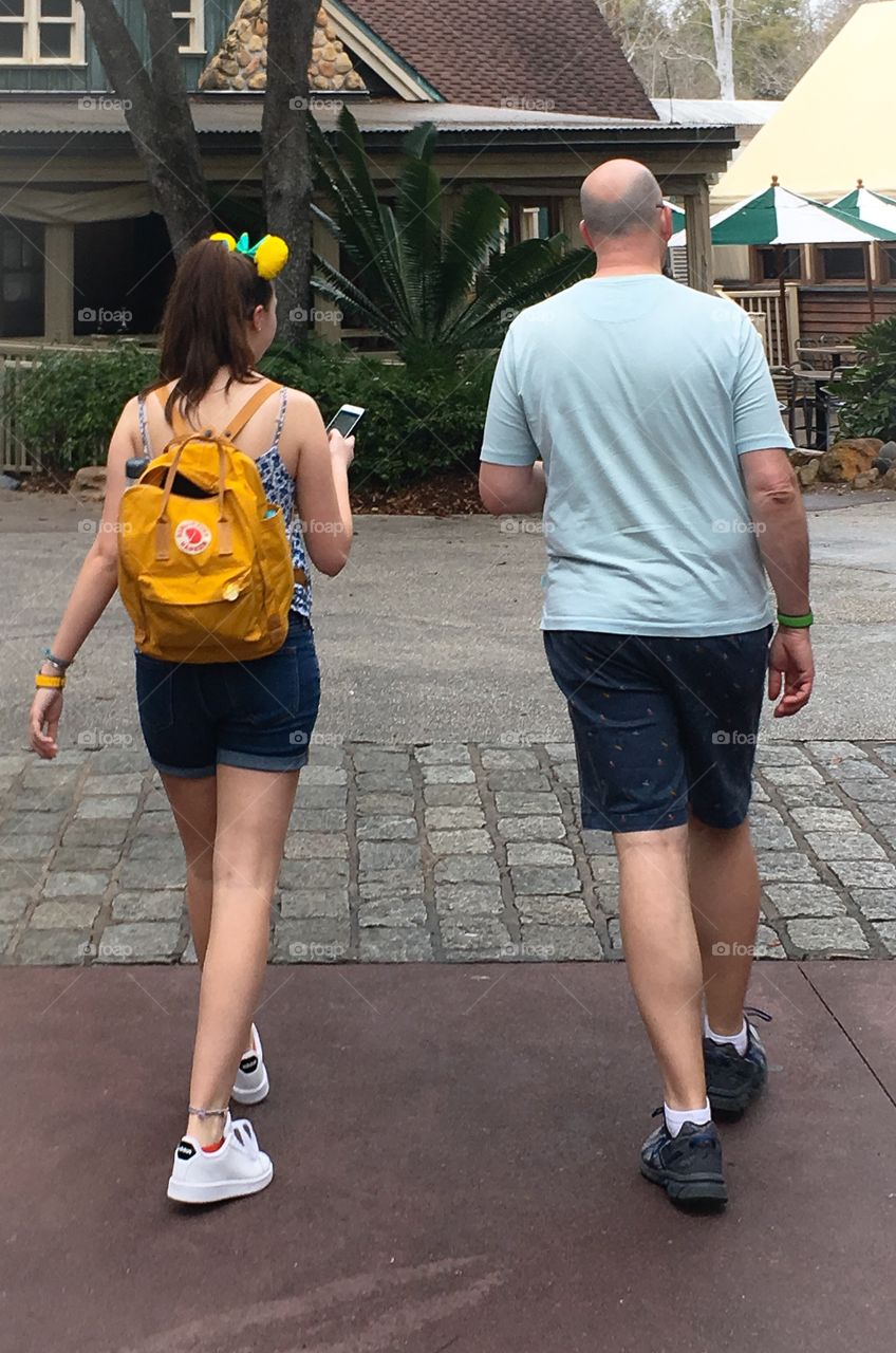 Walking on step - father and daughter walking together.  Long legs on both of them.