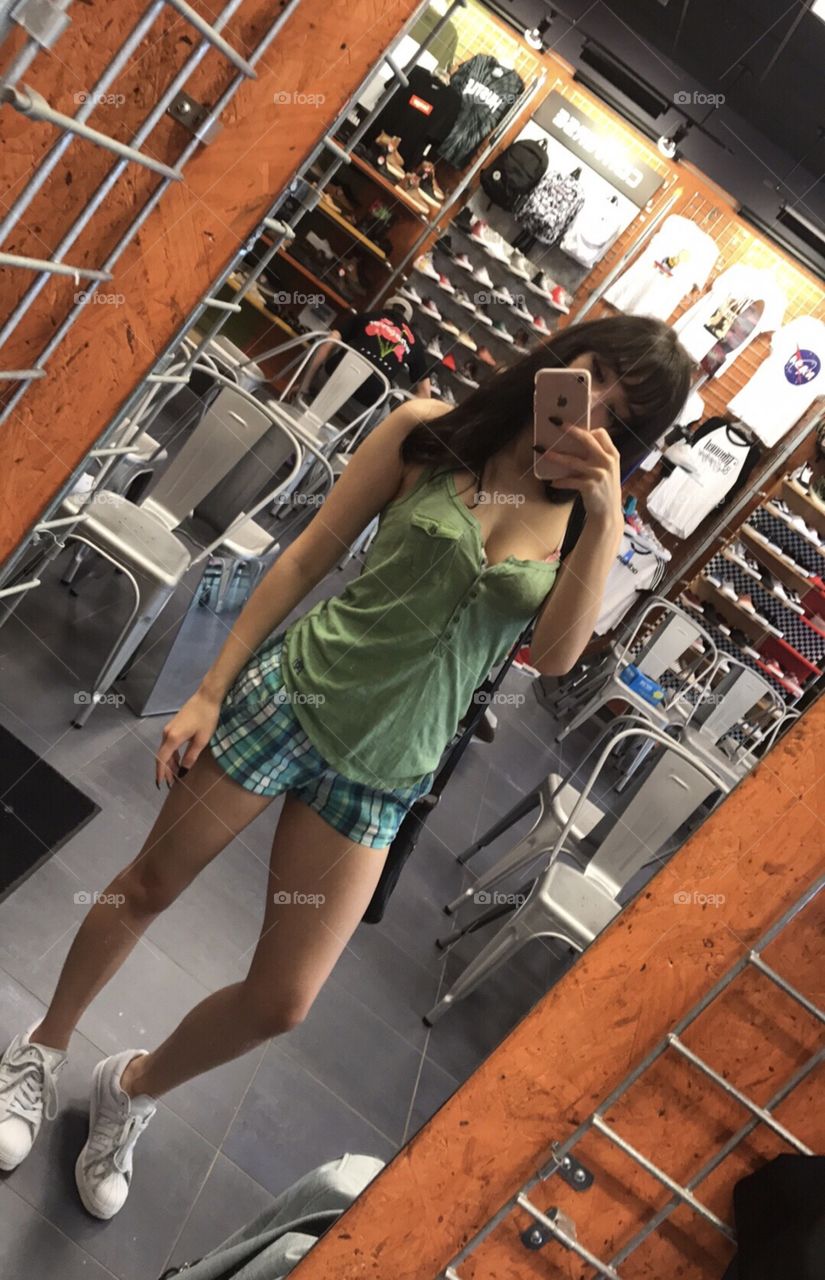 Reflection of woman taking selfie in mirror