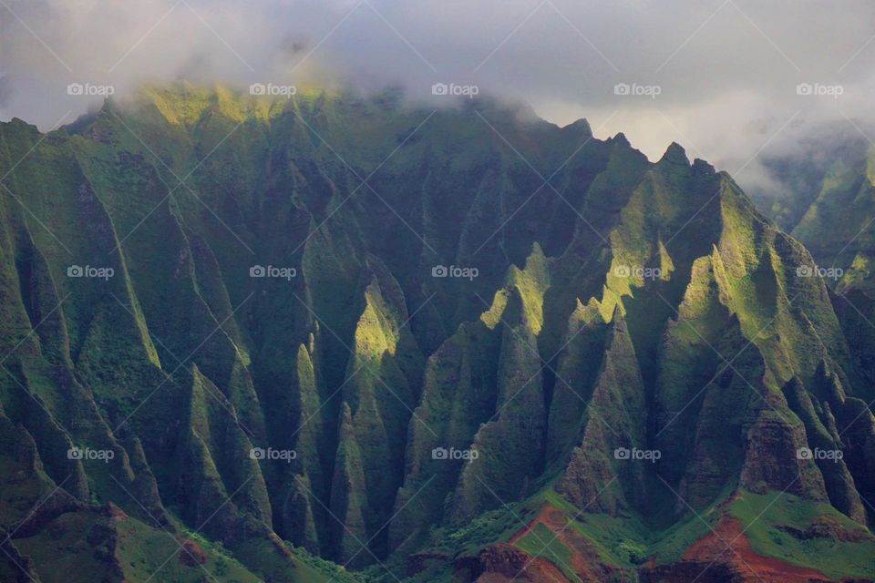The fantastic Napali coastline on the Hawaiian island of Kauai creates deep shadows from its sharp folds and crevices