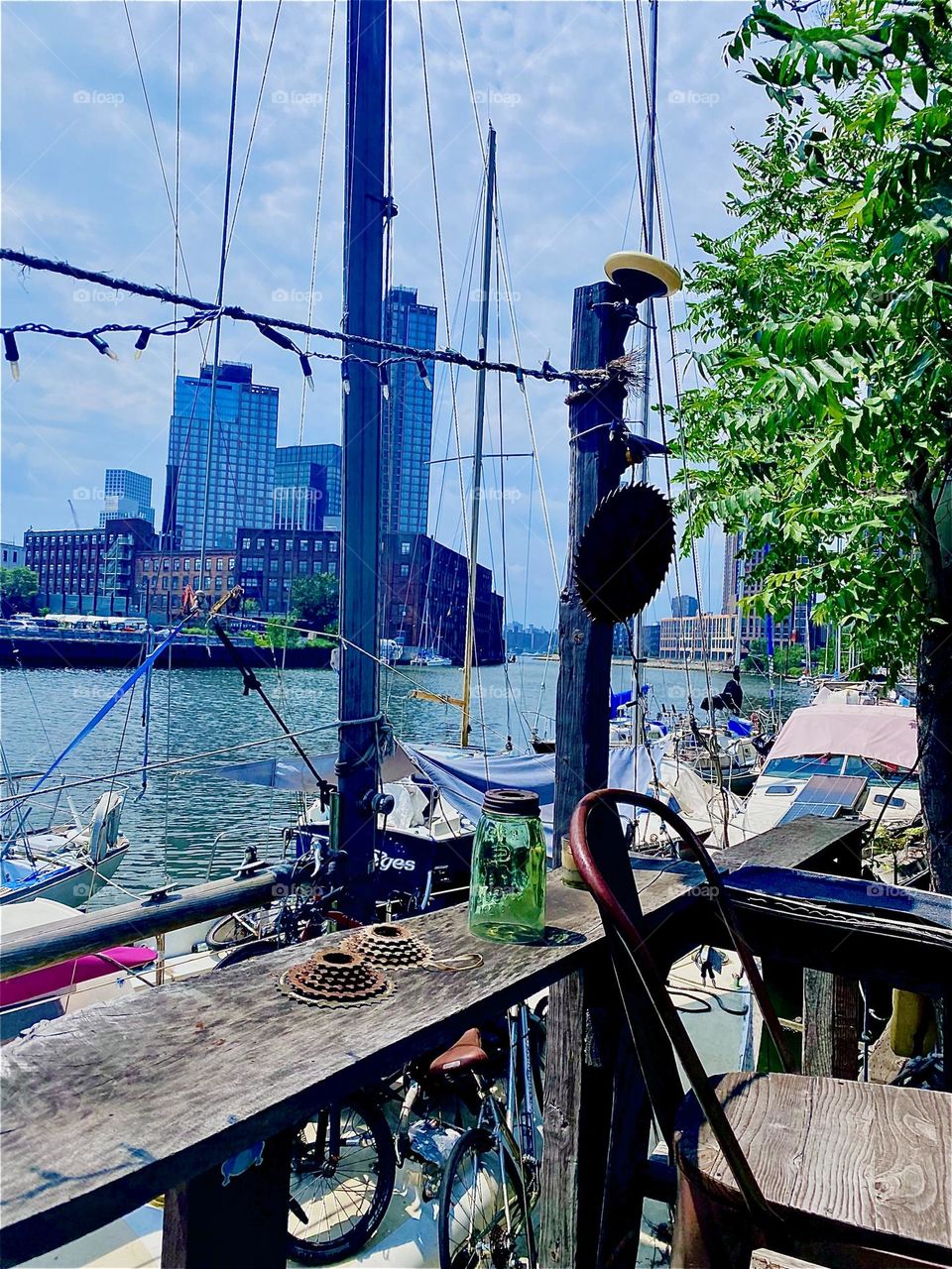 This beautiful view can be enjoyed from a handcrafted veranda at „Newtown Creek“ in LIC, Queens created by the locals who inhabit the boats to serve as a venue for get togethers, parties, summertime barbecues. 2023. Hypnotic Productions