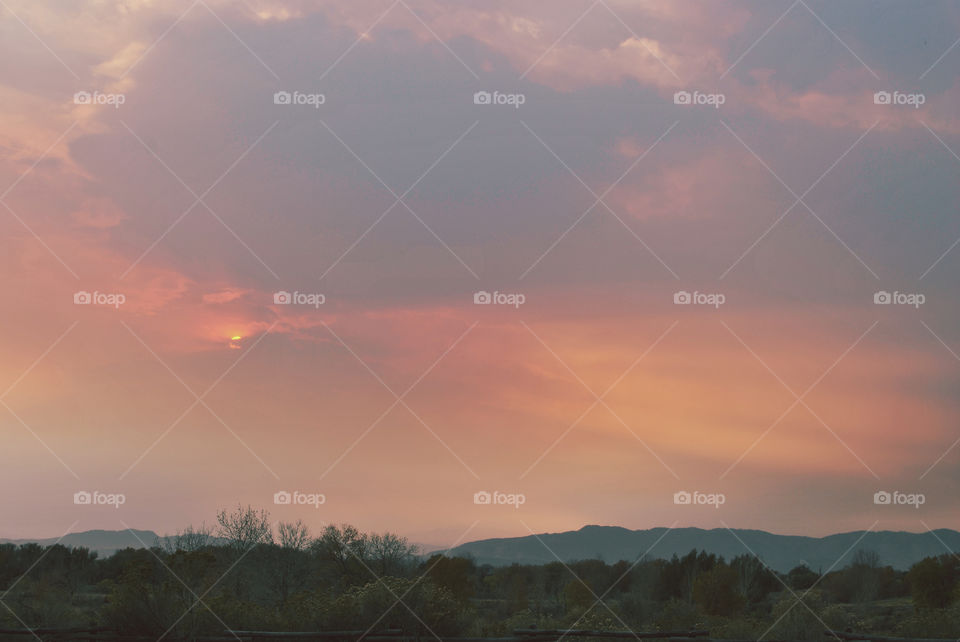 a beautiful sunset over the rocky mountain foothills. 