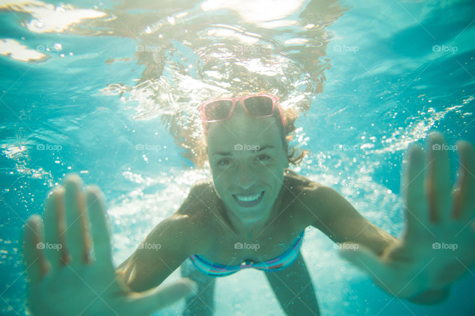 beautiful girl under water, summer mood, a girl with glasses and a smile.  clear clear water