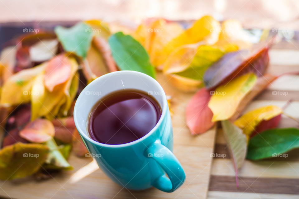 Hot flower tea in a blue mug on a wooden background