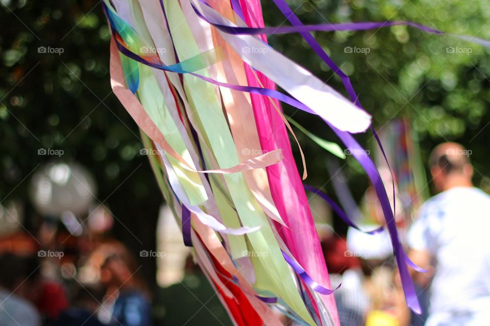 Colorful fluttering ribbons in the tree in front of people in the beer garden