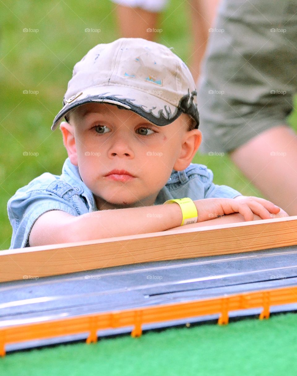 Boy looking. Child looking when people playing with a car track