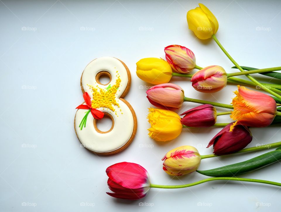 8 March gingerbread and colorful tulips on a white background women's day