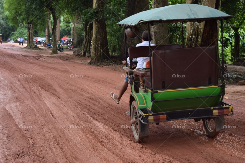 Poor streets of Cambodia . A rickshaw driver having problems with the poor streets of Cambodia 