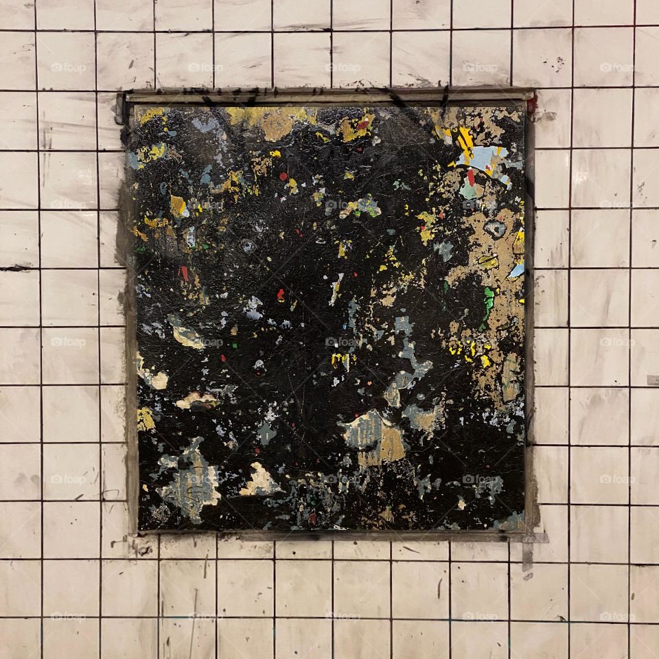 Layers of old, torn advertising posters on a subway wall