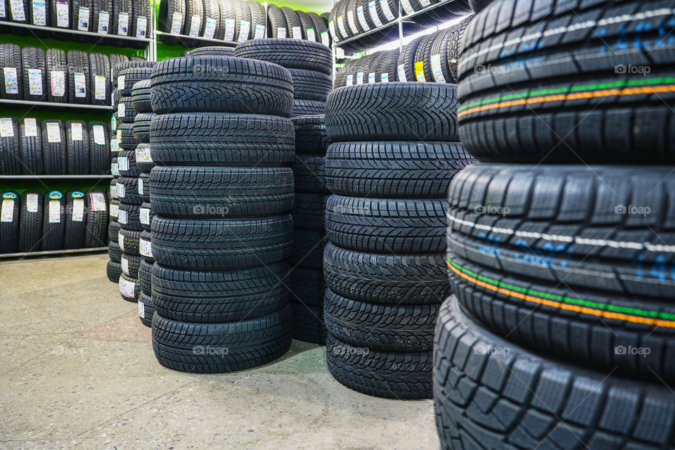 rack with variety of new car tyres in automobile store, selective focus