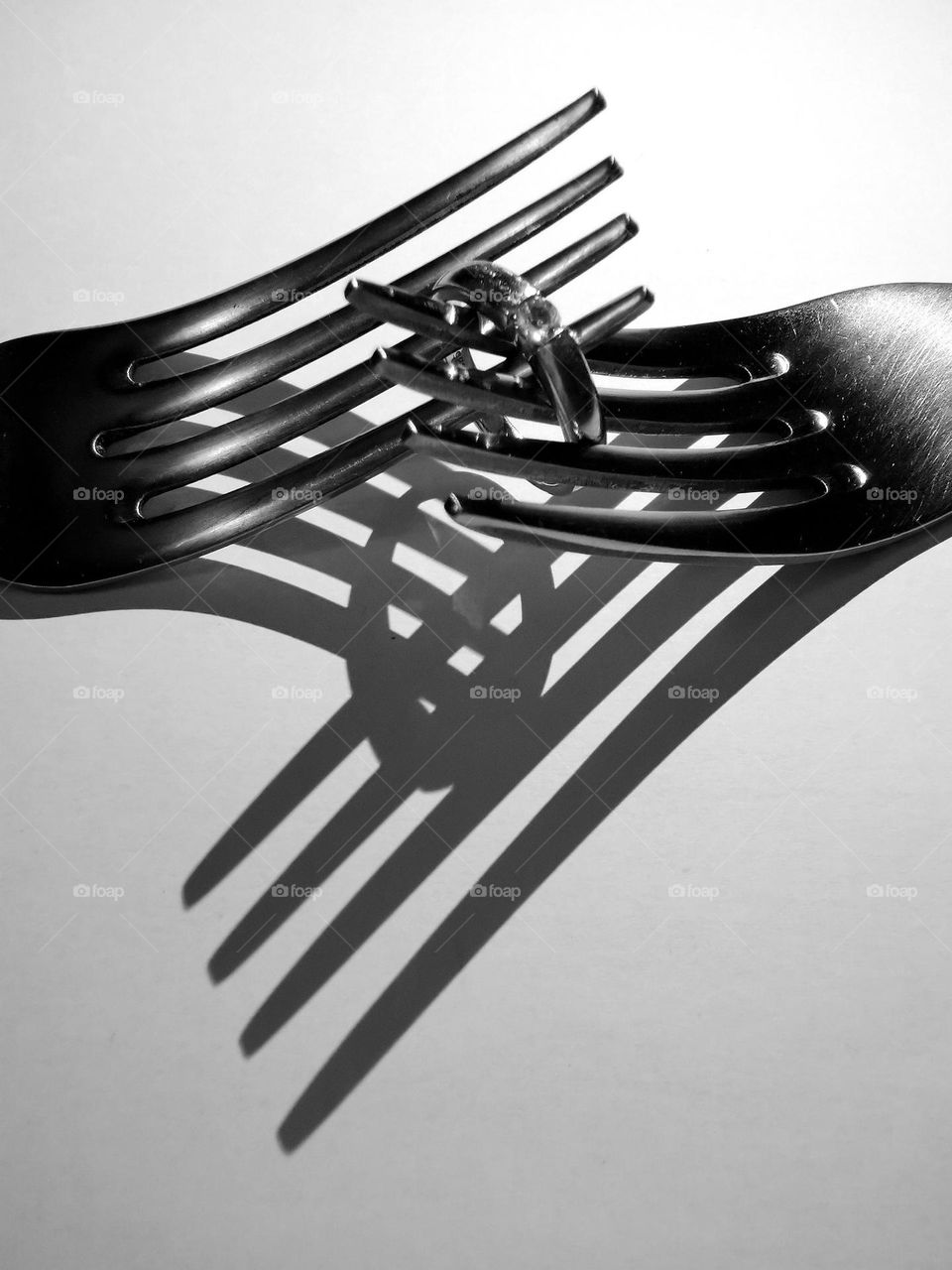 Two kitchen forks and engagement ring. Nice shadows. Not ordinary black and white photography.