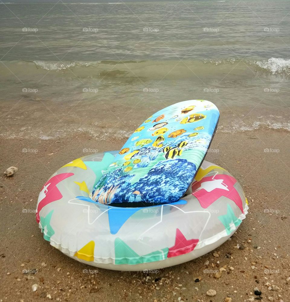 Swimming board and ring on the beach