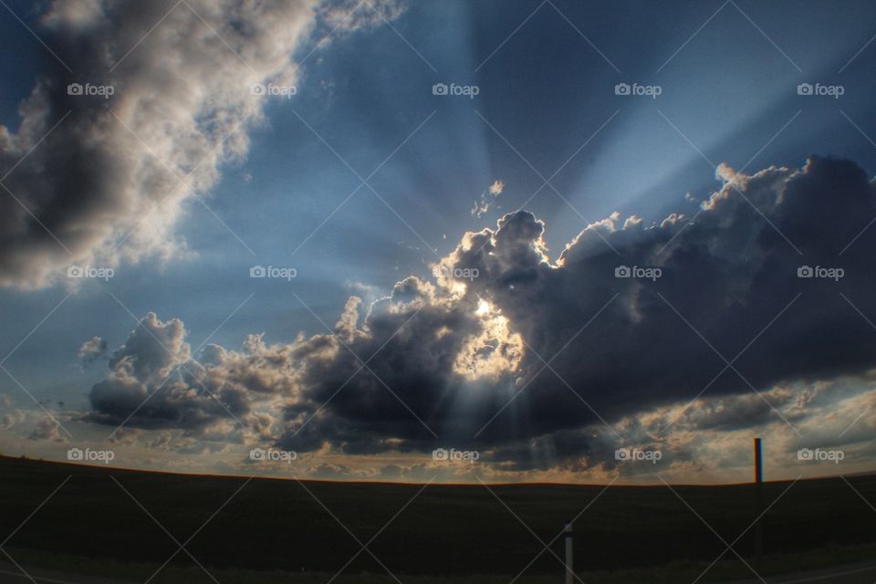 sun behind a cloud with a hole in the cloud