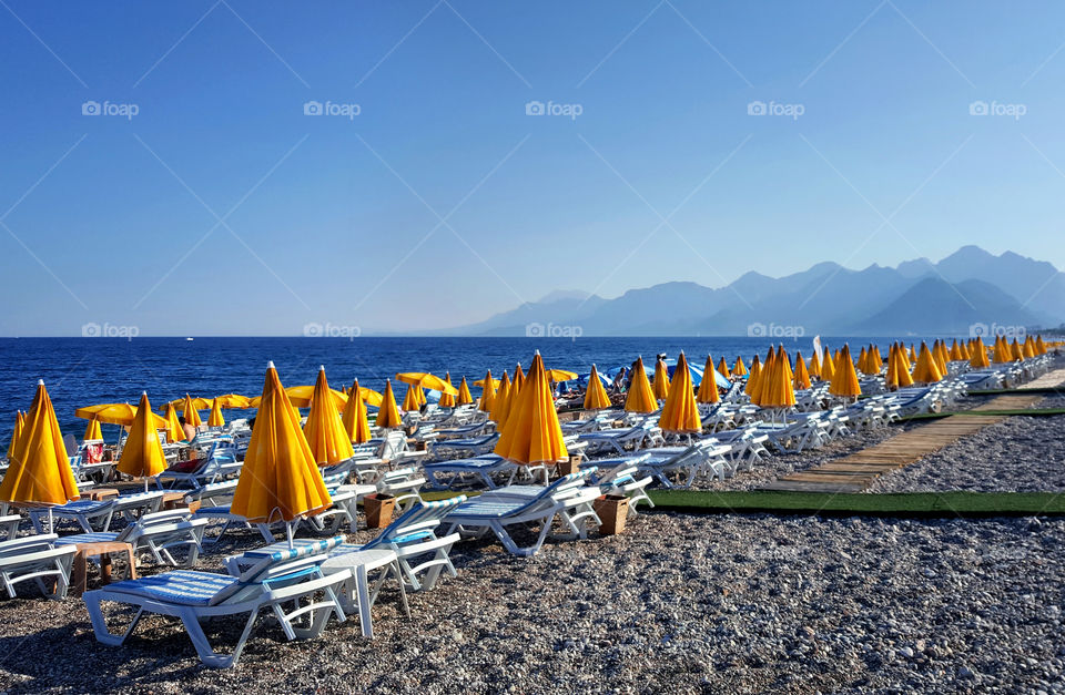 a lot of yellow parasols on the Mediterranean seaside in antalya