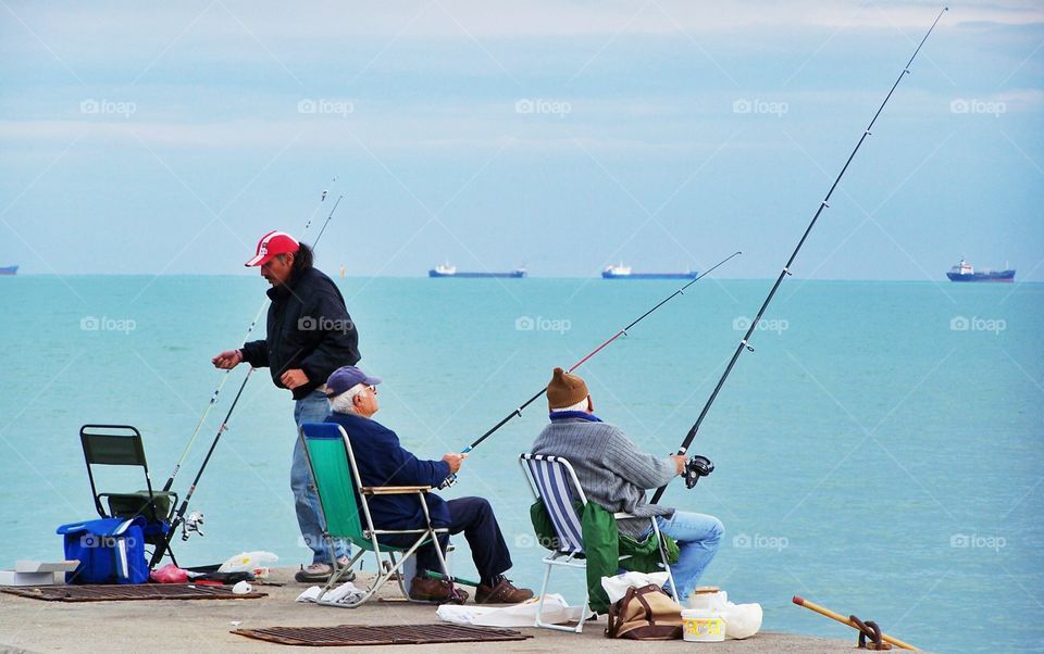 two old friends are fishing and chatting in Mersin, Turkey.