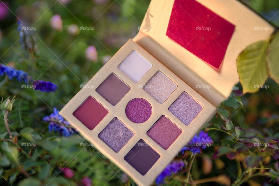 Eye shadow palette on floral background.