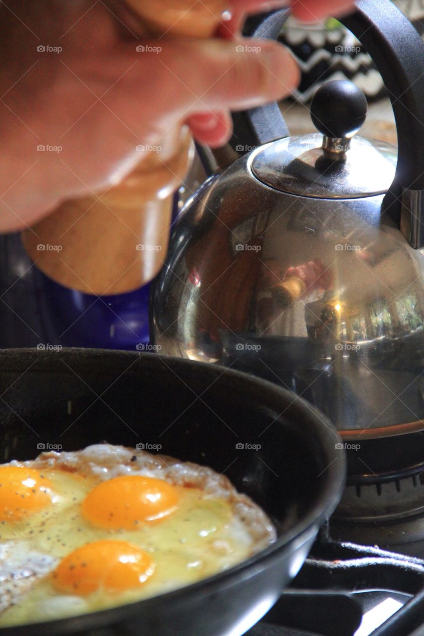 Sunday Morning. Cooking eggs up close,with a teapot in the background