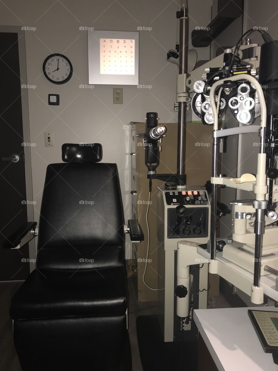 This is an Ophthalmologist exam room complete with an exam chair, slit lamp, phoropter, and other modern medical equipment. 