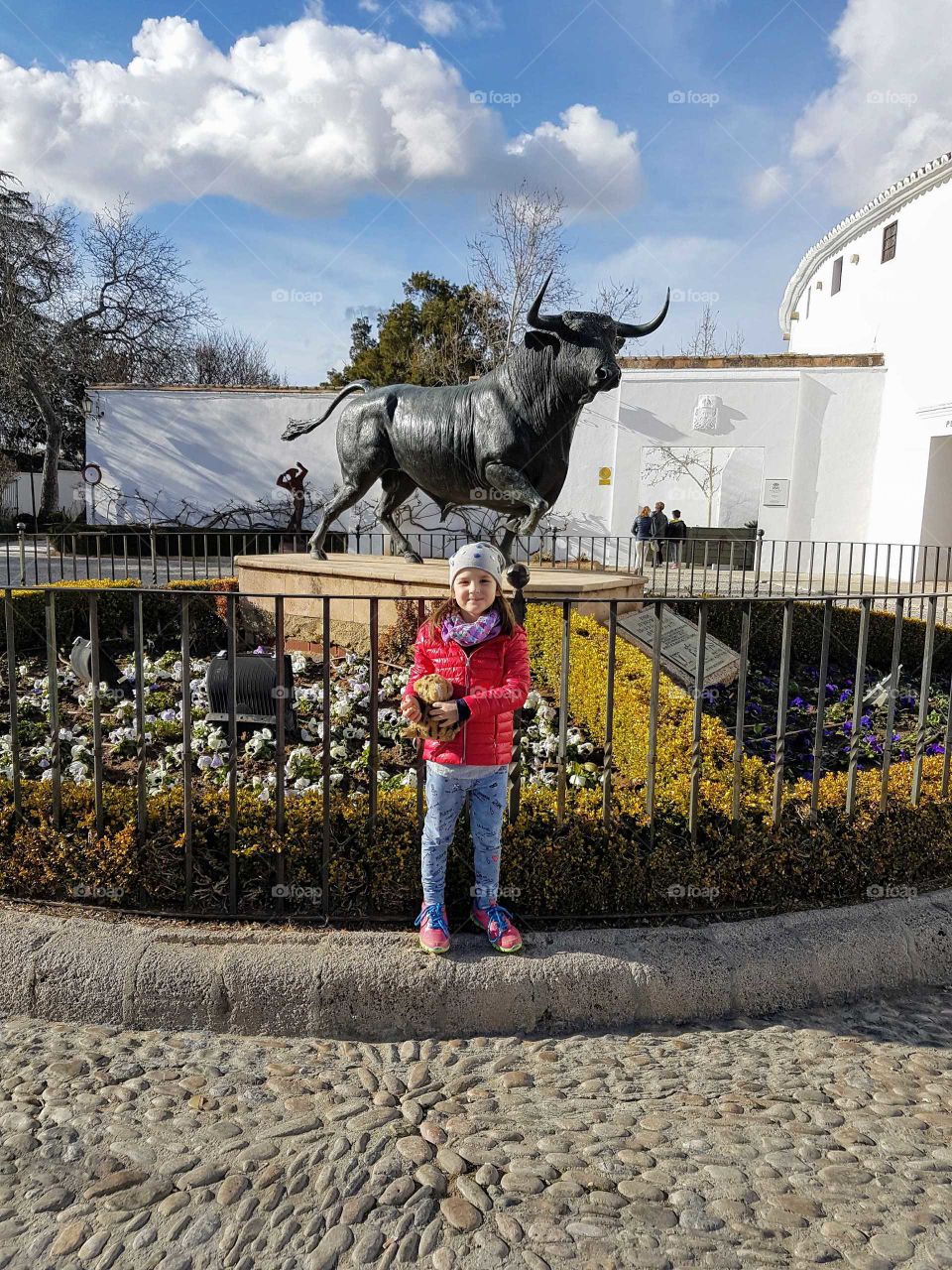 Little girl standing near bull state in Ronda, Spain