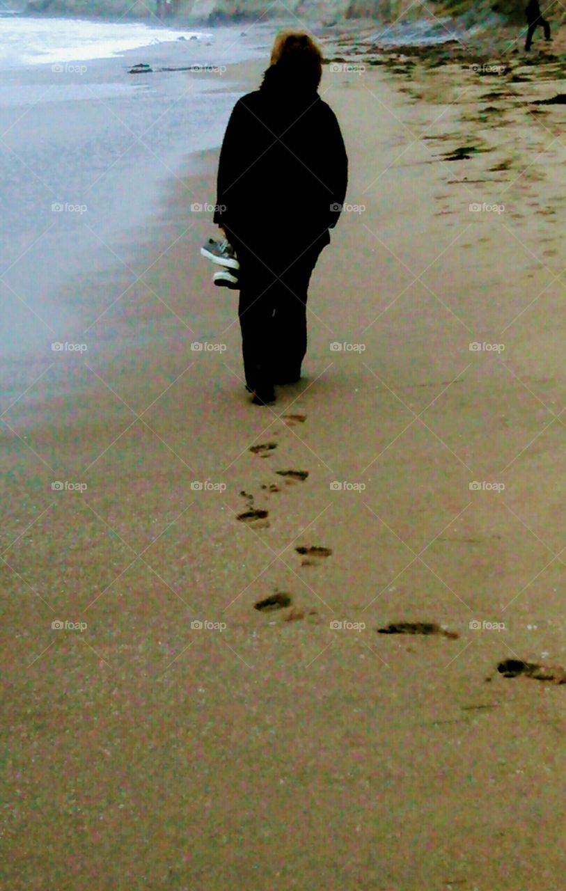 As she walks, footprints in sand, it's as if the years pass and her childhood is over before her mother's eyes.