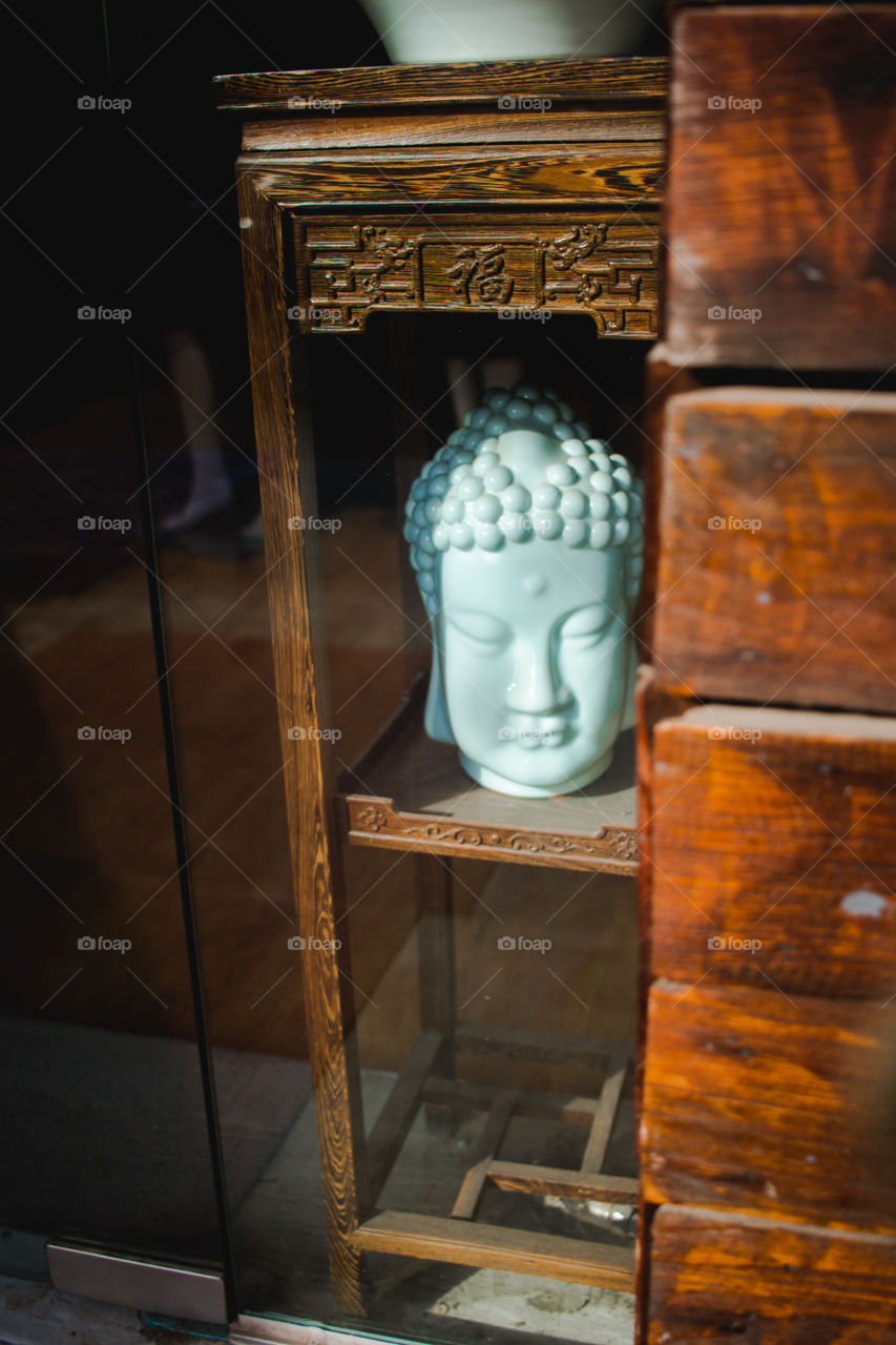 Buddha, statue, shop window,wood, brown, turquoise, glass