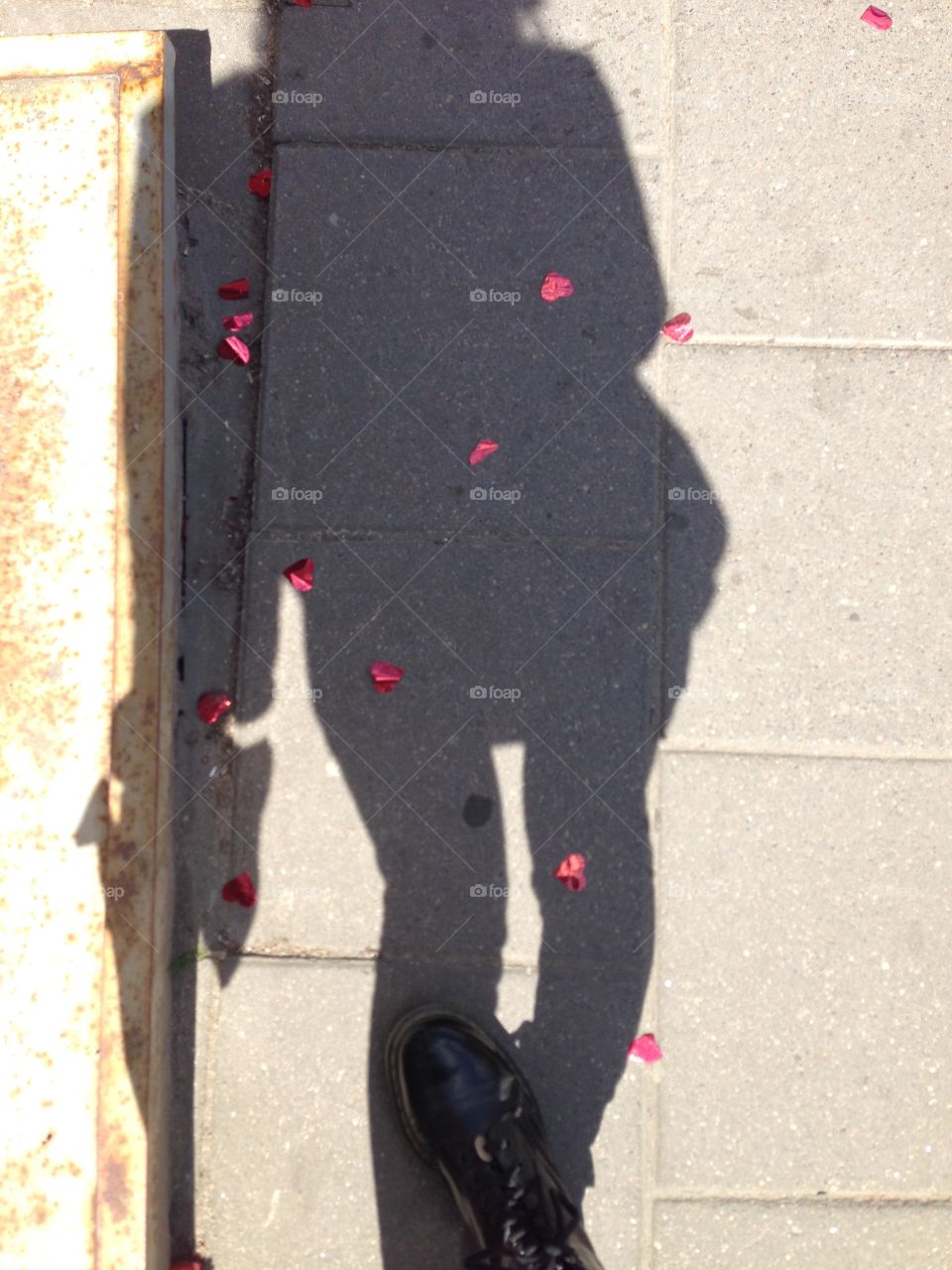 Somebody had a celebration on the street. My shadow on the confeti.