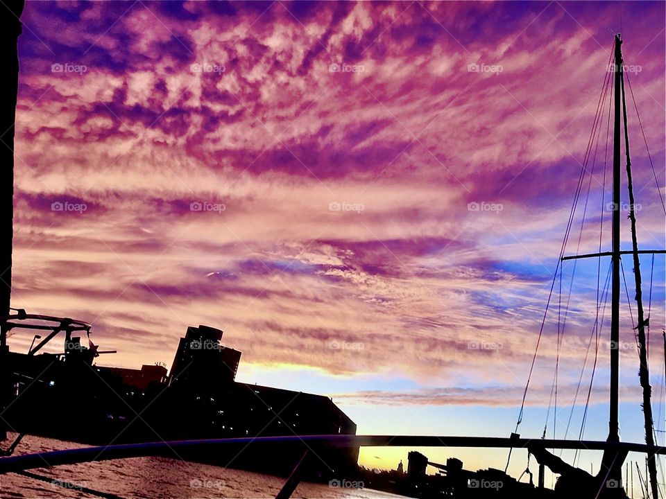 A dramatic cloud formation in the evening sky over Newtown Creek in Long Island City, Queens, NY photographed from aboard our boat, the “Salvation”. The clouds are reflecting the setting sun’s last rays in magenta and pink. 2021. Hypnotic Productions