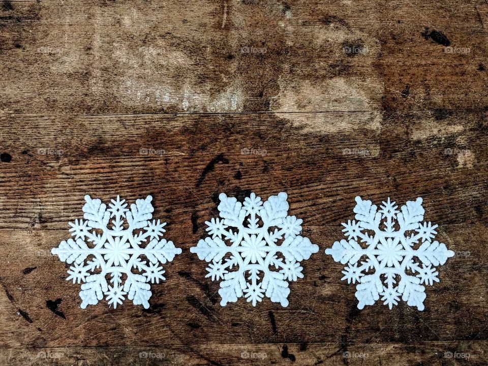three snowflakes on a wooden background
