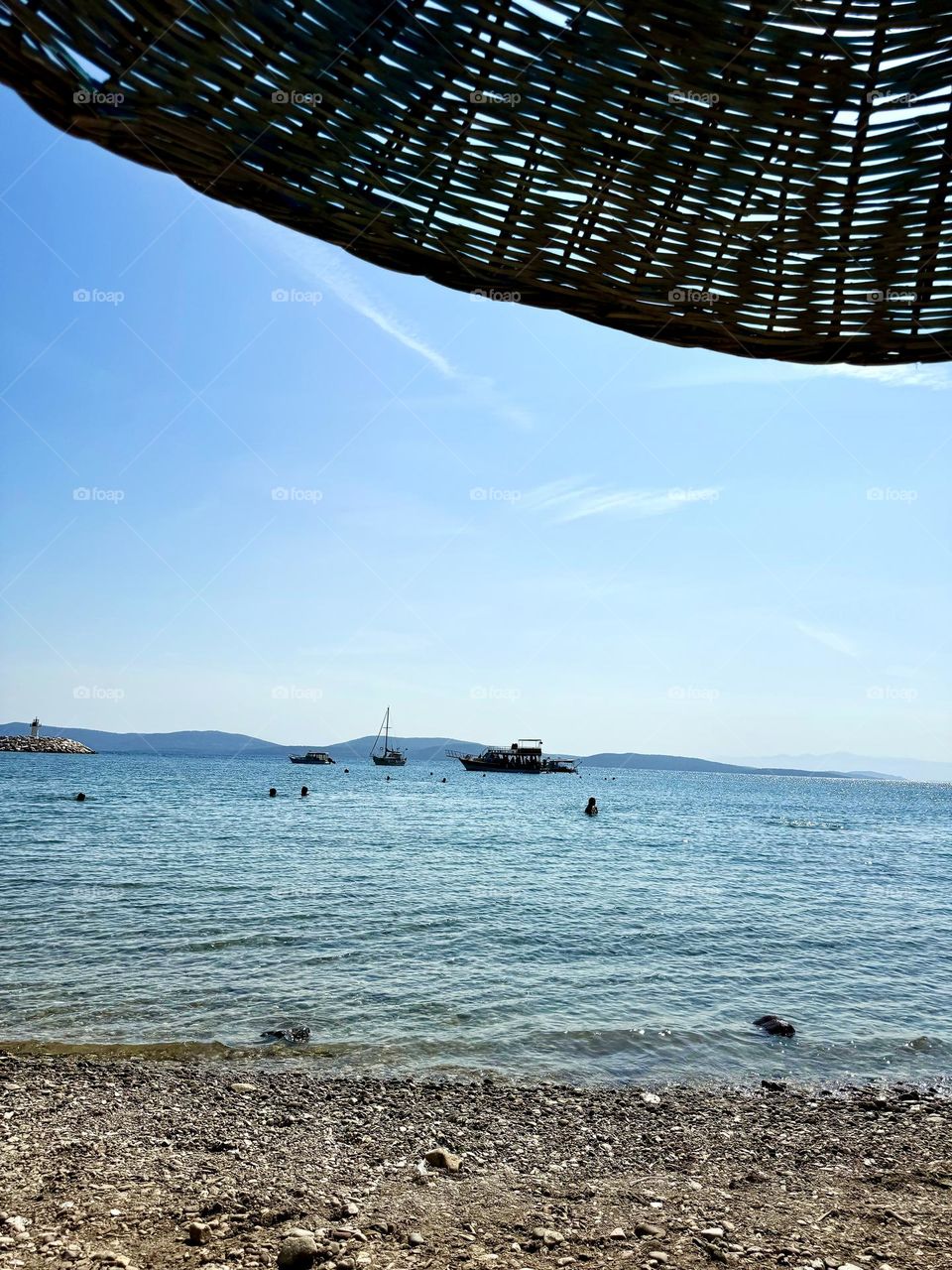 Relaxing on the beach on the seashore. Beach umbrella, sea, sand, mountains, ships