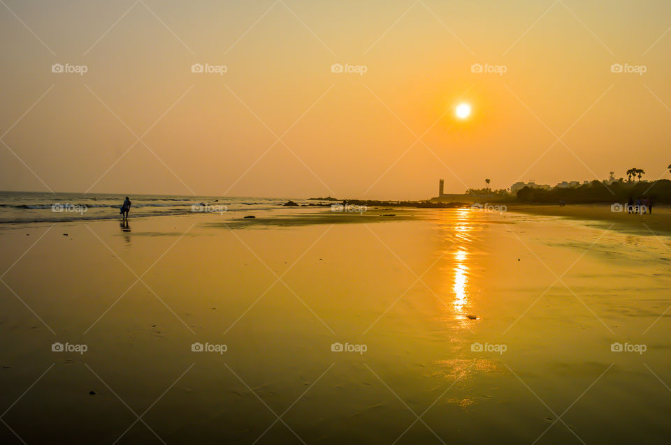 Beautiful sea shore at sunset. Wild Empty Tropical beach, blue sky, sunlight reflections on coast sunny day. Travel vacation concept. Image is exciting, bright, sensational, tranquil, calm, stunning