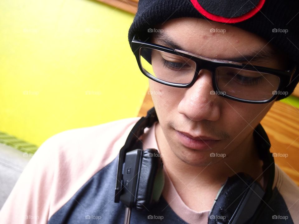 teenage boy wearing bonnet using a smartphone