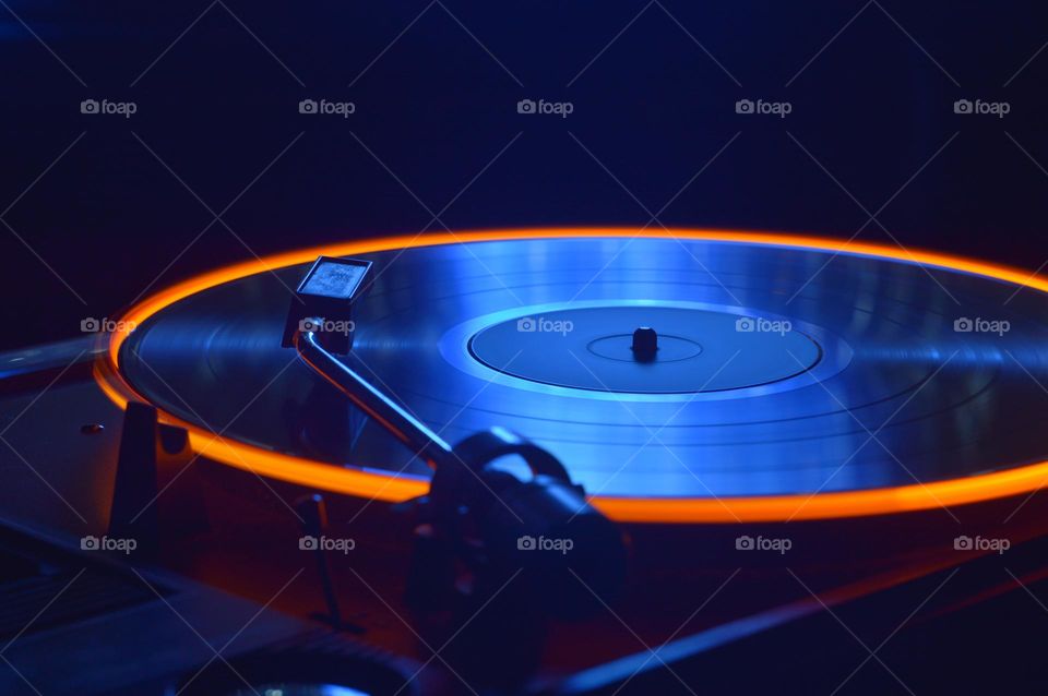 A vinyl record is played on a gramophone with a light attached to the edge of the record. taken with a shutter speed of 4 seconds.