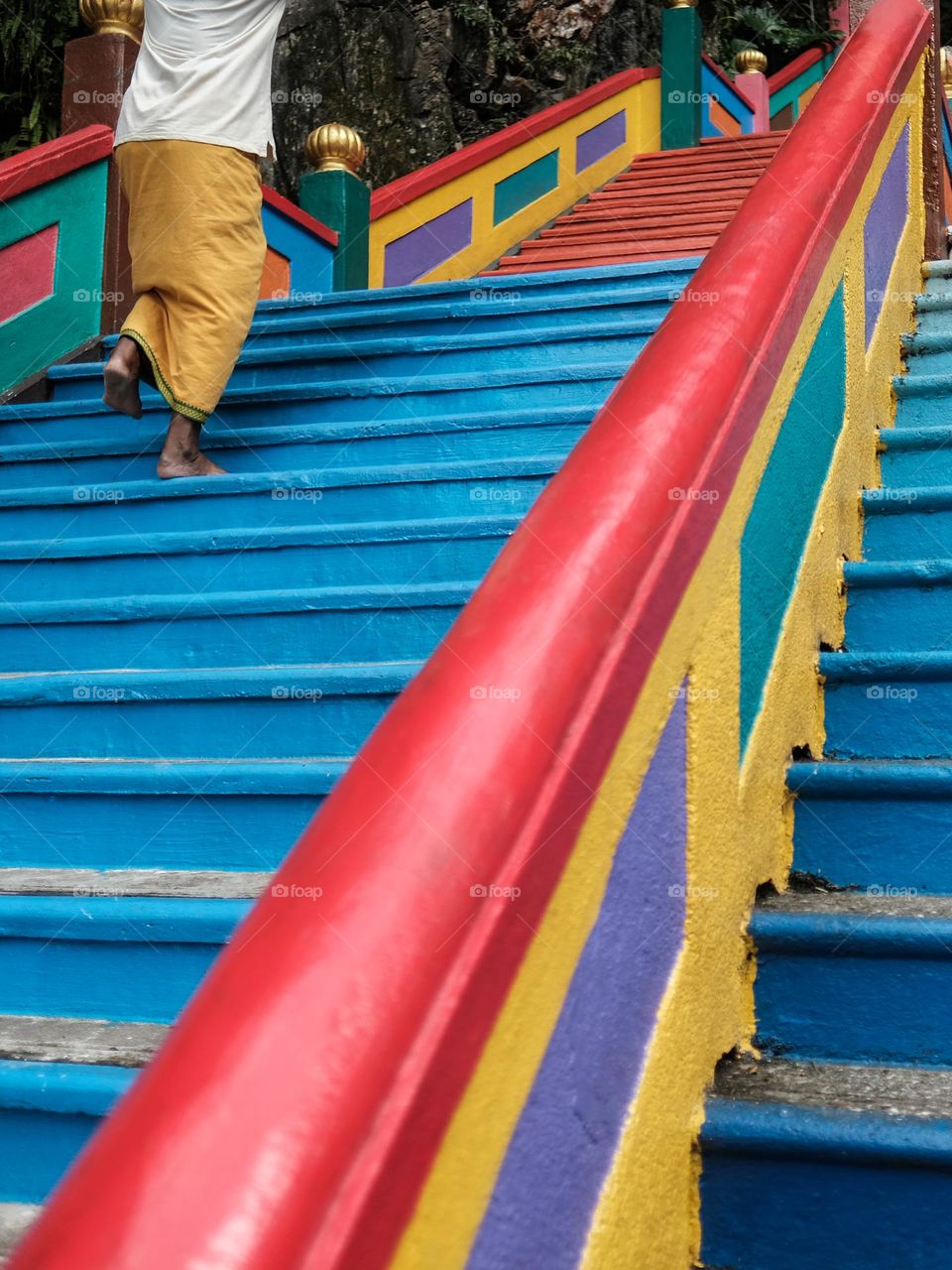 Climbing up Batu Caves colorful steps