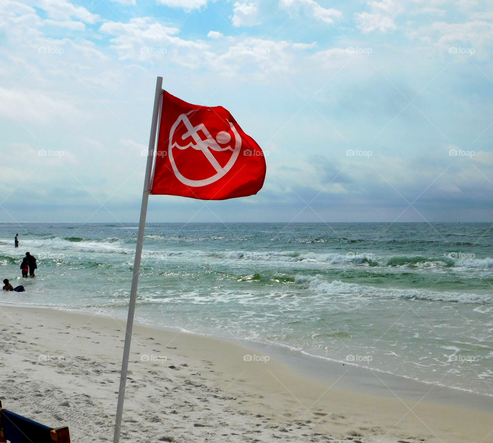 No swimming warning sign on flag at beach