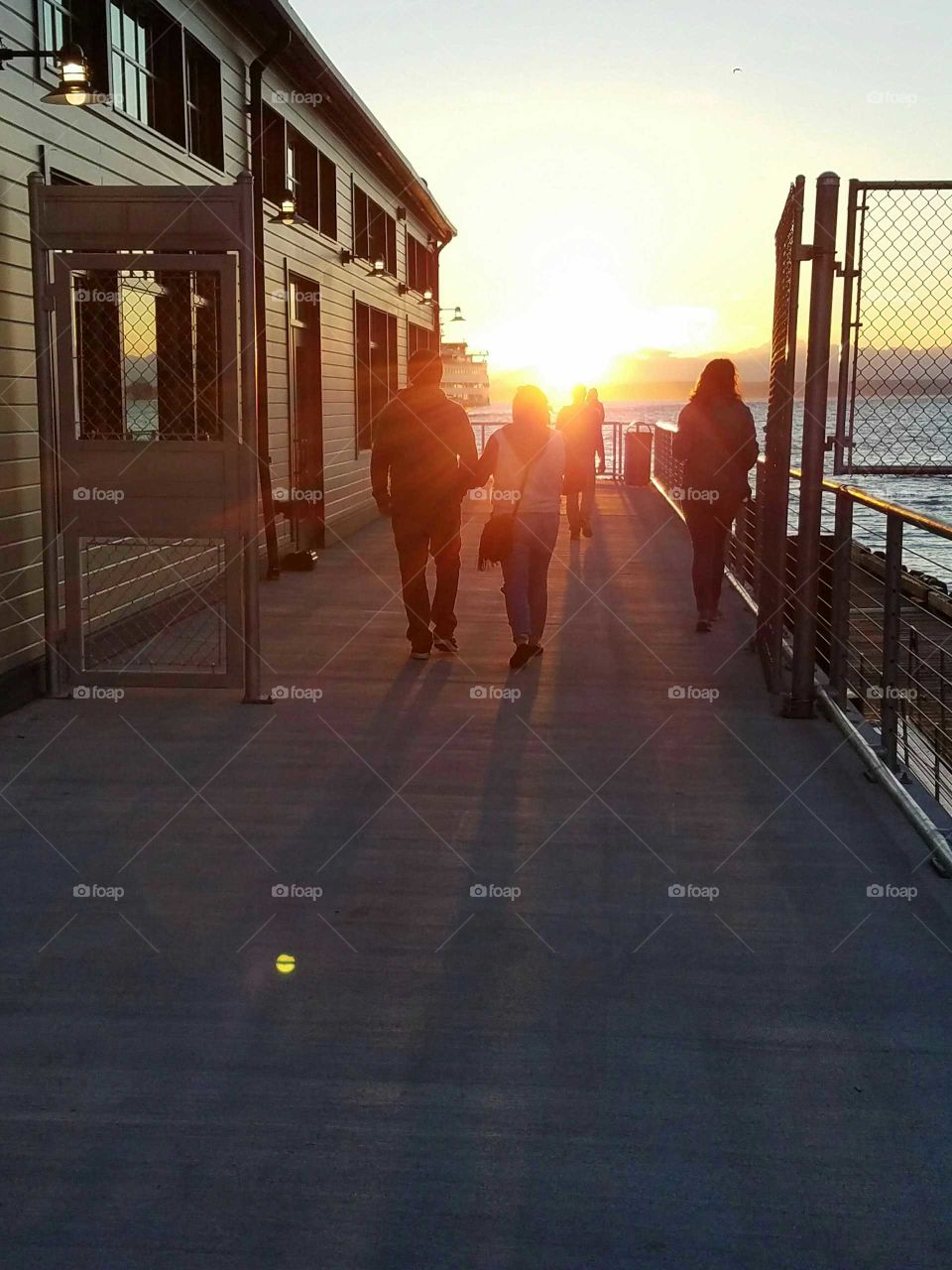 People at dock during sunset